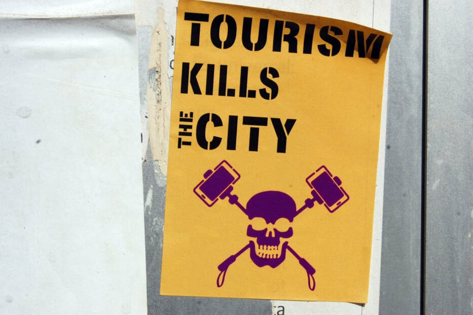 Manchmal bekommen Touristen den Ärger auch deutlich zu sehen - wier hier in Spanien auf diesem Aufkleber mit der Aufschrift "Tourismus tötet die Stadt".