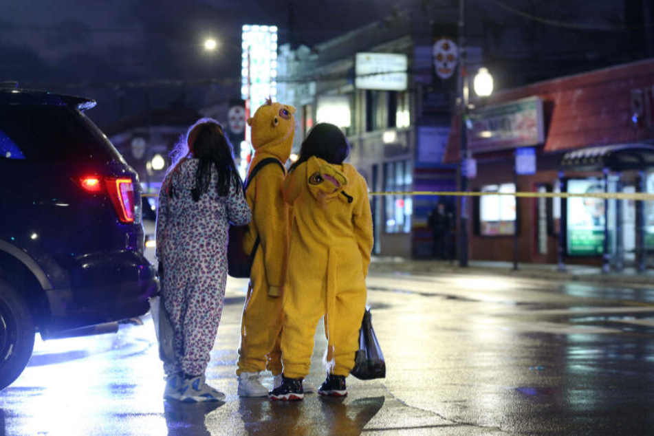 Kinder stehen in Chicago in der Nähe des Tatorts, an dem ein siebenjähriges Mädchen an Halloween von einer verirrten Kugel getroffen und lebensgefährlich verletzt wurde.