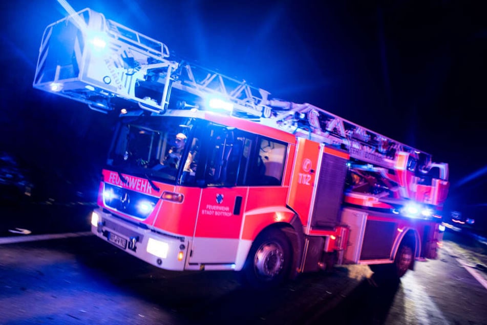 Ein Drehleiterwagen der Feuerwehr fährt mit Blaulicht (Symbolbild).