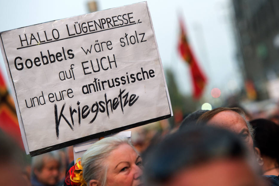 PEGIDA-Demonstranten halten ein "Lügenpresse"-Plakat in die Höhe.