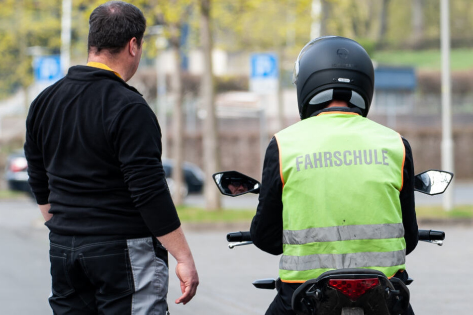 Ein Fahrlehrer erklärt einem Schüler das Motorradfahren. (Symbolbild)