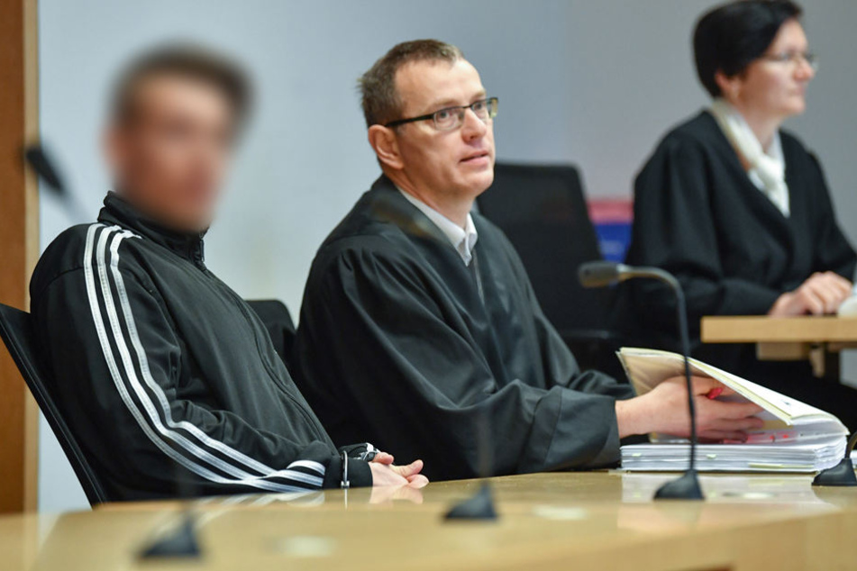 Der Angeklagte (l), im Dreifachmordprozess von Ostbrandenburg, sitzt neben seinem Anwalt Stefan Böhme in einem Verhandlungssaal.