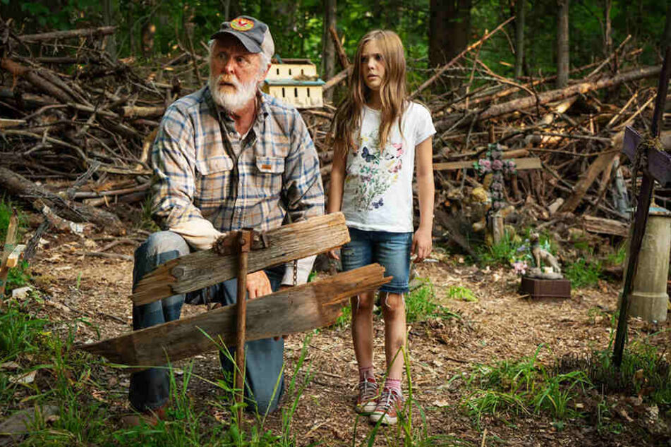 Jud Crandall (l., John Lithgow) schließt die kleine Ellie (Jeté Laurence) ins Herz und warnt sie auch deshalb vor dem Friedhof der Kuscheltiere.