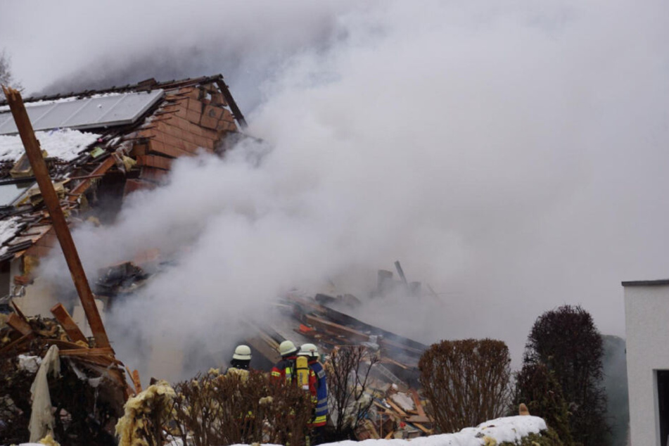 Feuerwehrleute vor dem Haus, das schwer beschädigt wurde.