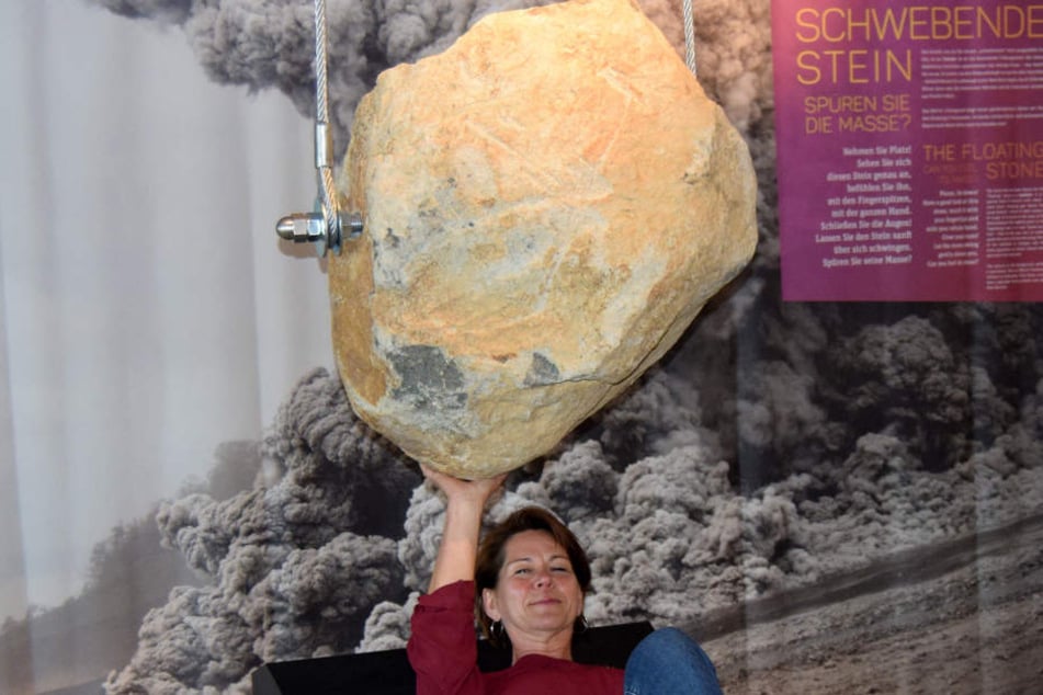 Eine Mitarbeiterin der Gesellschaft für Tourismus und Stadtmarketing Schotten liegt unter dem "Hängenden Stein" im Erlebnismuseum.