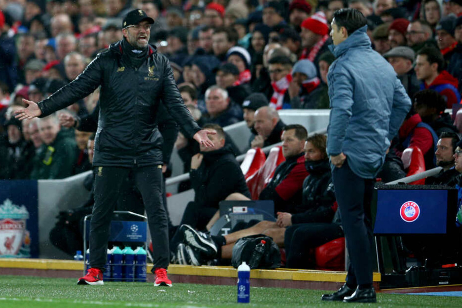 Trainer Jürgen Klopp von Liverpool gestikuliert an der Seitenlinie neben Trainer Niko Kovac von München.