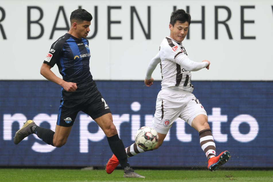 Paderborns Mohamed Dräger (links, SC Paderborn 07) im Kampf um den Ball mit Ryo Miyaichi aus Hamburg.