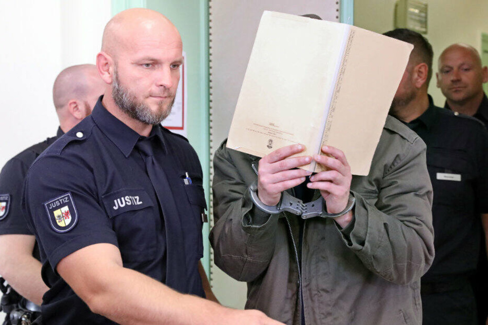 Der Angeklagte wird in den Gerichtssaal geführt.