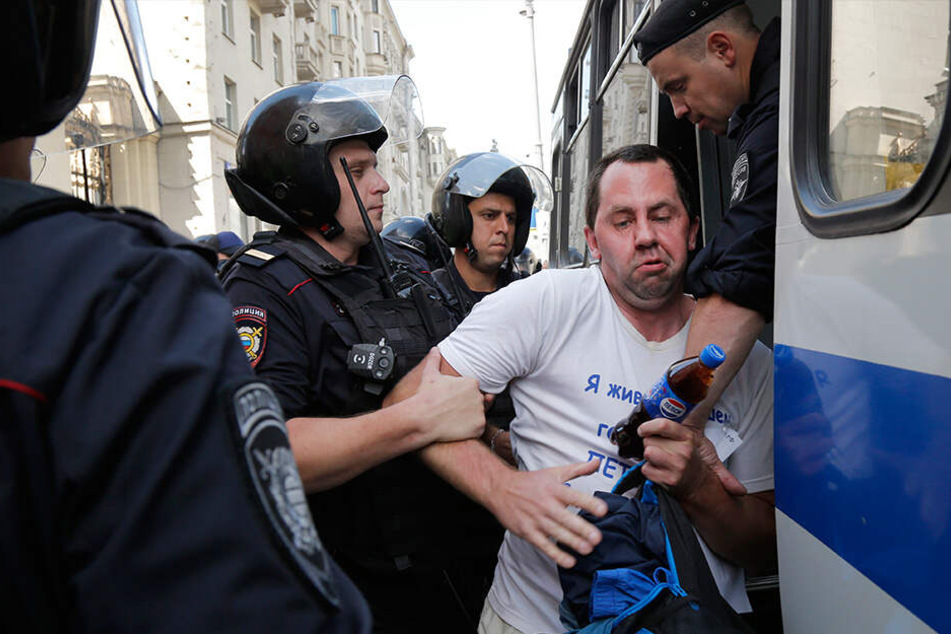 Polizeibeamte verhaften einen Mann, der bei der nicht genehmigten Kundgebung protestierte.