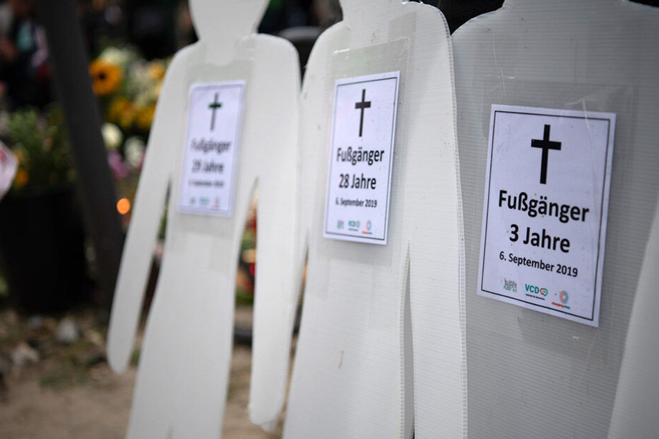 Pappfiguren, mit Zetteln beklebt, stehen an der Unfallstelle.