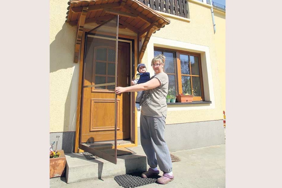 Der Balkon abgehangen, Fenster und Türen mit Fliegengittern eingerüstet. Drobenerin Kathrin Zuschke (47) mit Enkel Melias (7 Monate), der wegen der Quälgeister Probleme beim Schlafen hat.