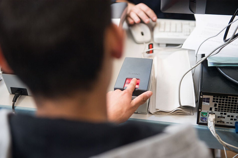Ein Flüchtling wird in der Registrierungsstelle für unbegleitete, minderjährige Flüchtlinge in Stuttgart mithilfe eines Fingerabdruckscanners auf einen bestehenden Datenbank-Eintrag überprüft.