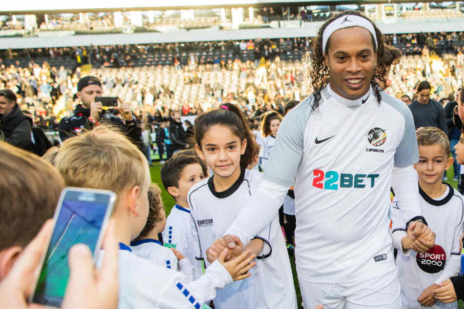 Der ehemalige brasilianische Fussballprofi Ronaldinho lief mit Kindern an der Hand in die Commerzbank-Arena ein.