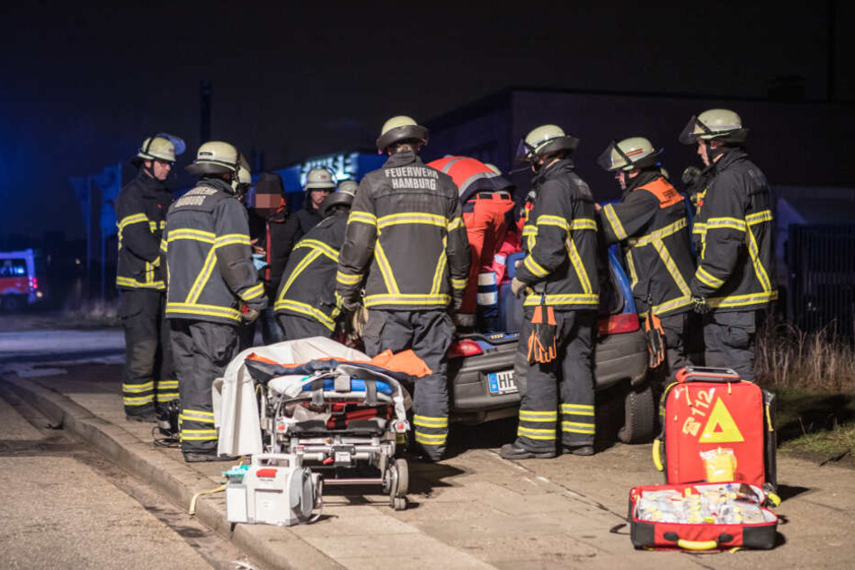 Einsatzkräfte stehen am verunfallten Fahrzeug.
