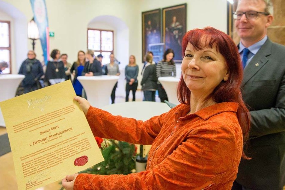 Autorin Sabine Ebert (59) zeigt stolz ihre Bestellungsurkunde als erste Stadtschreiberin von Freiberg.