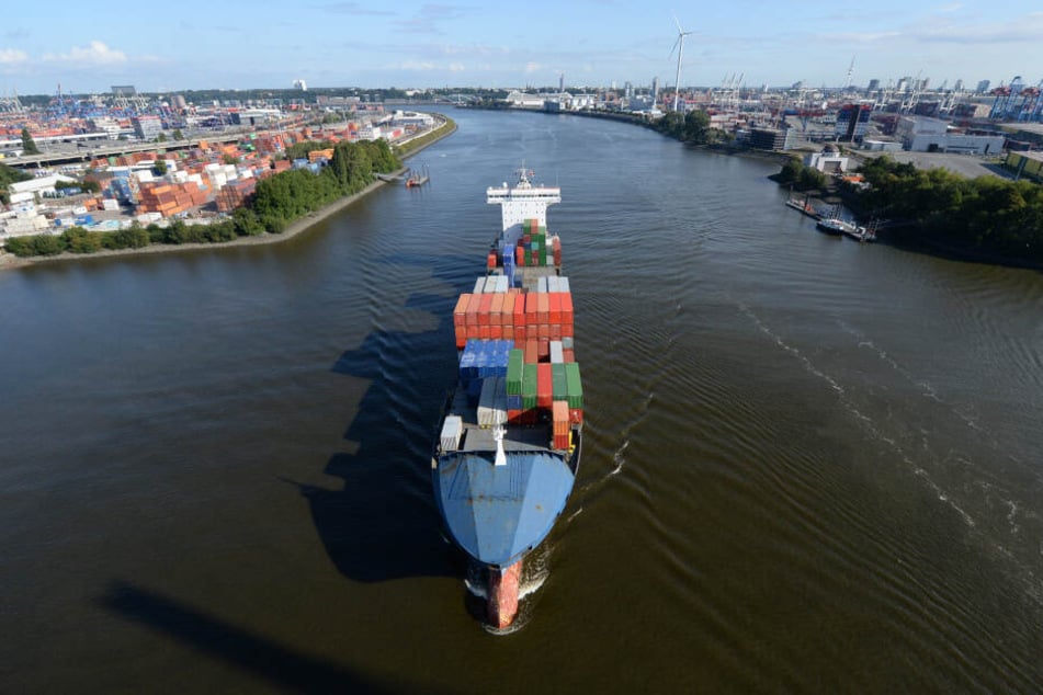 Ein großes Containerschiff ist auf der Elbe bei Hamburg unterwegs.