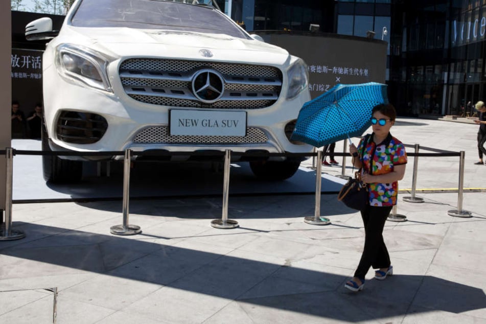 Eine Frau läuft in Peking an einem riesigen Modell des Mercedes GLA vorbei. In der chinesischen Stadt laufen nun die meisten Autos der Stuttgarter vom Band. (Archivfoto)