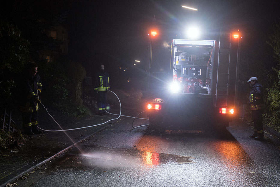 Feuerwehrmänner reinigen die Straße in der Nähe des Tatorts.