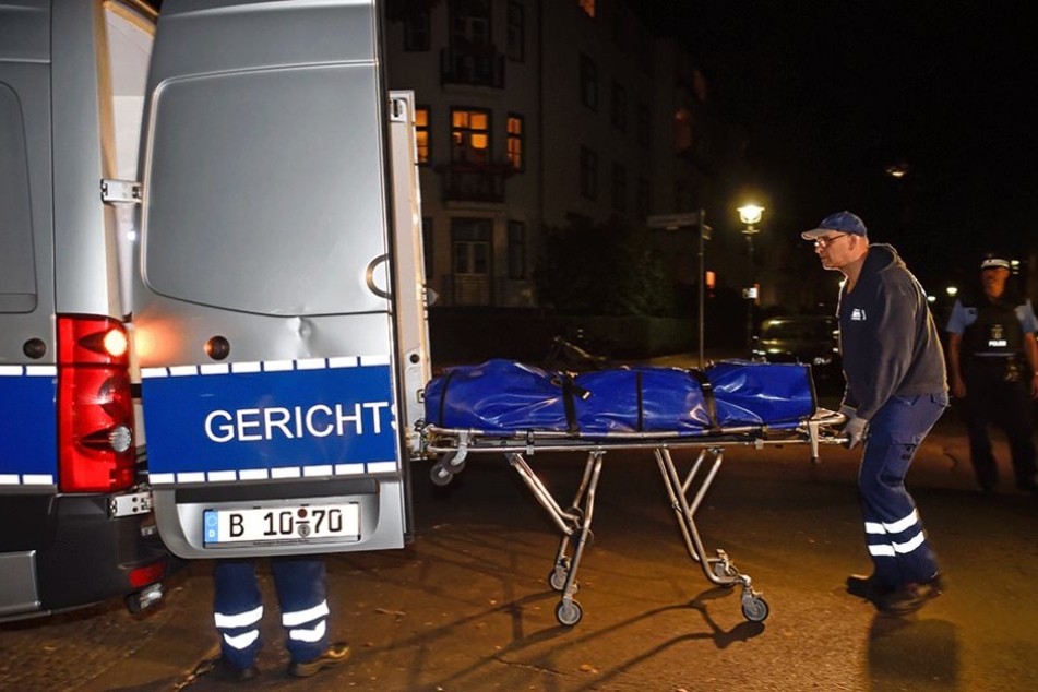 Mitarbeiter der Gerichtsmedizin transportieren den Leichnam zu ihrem Fahrzeug.