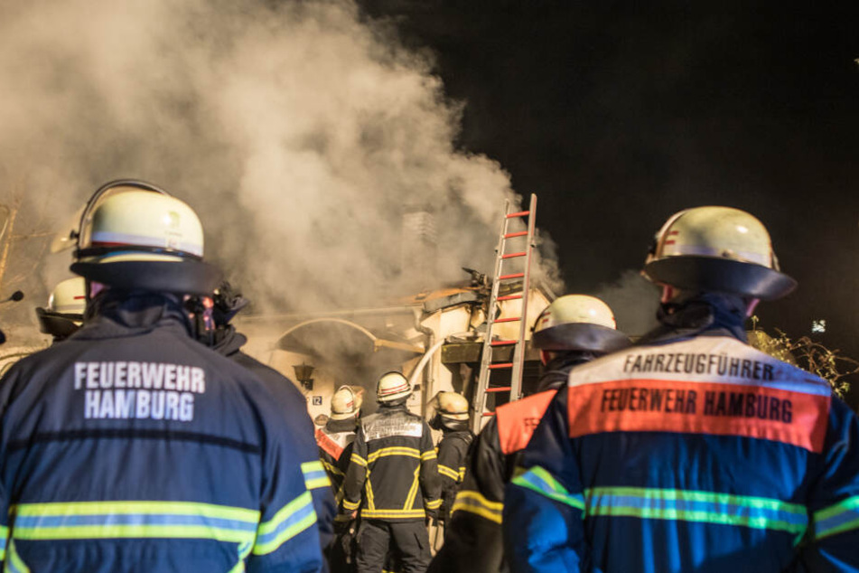 Dichte Rauchschwaben zogen über den Himmel, zahlreiche Einsatzkräfte stehen vor dem brennenden Haus.