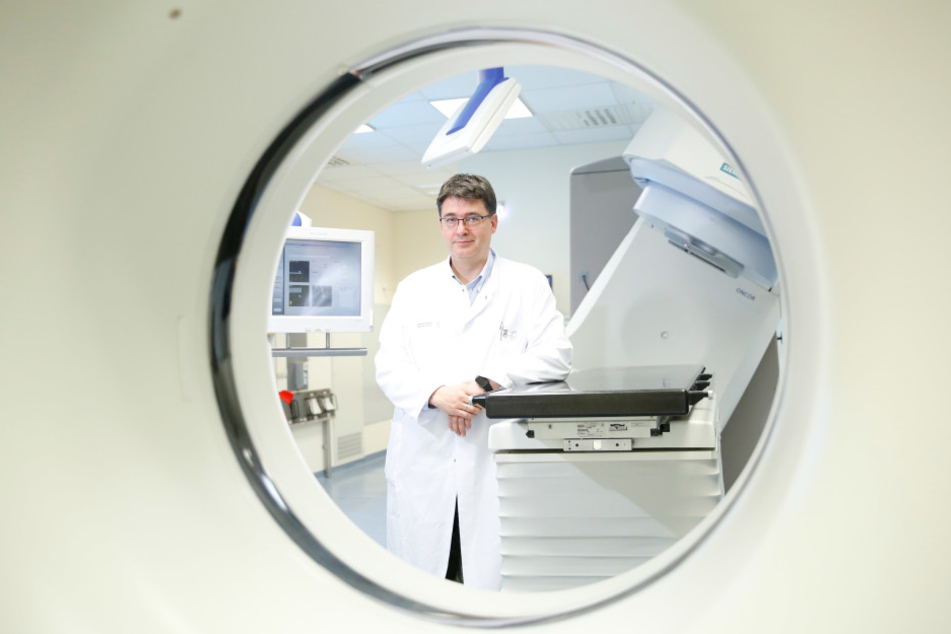 Professor Michael Baumann (53) an seinem früheren Arbeitsplatz: Dieser Linearbeschleuniger im „OncoRay“ kann 360 Grad um einen Patienten herumfahren.