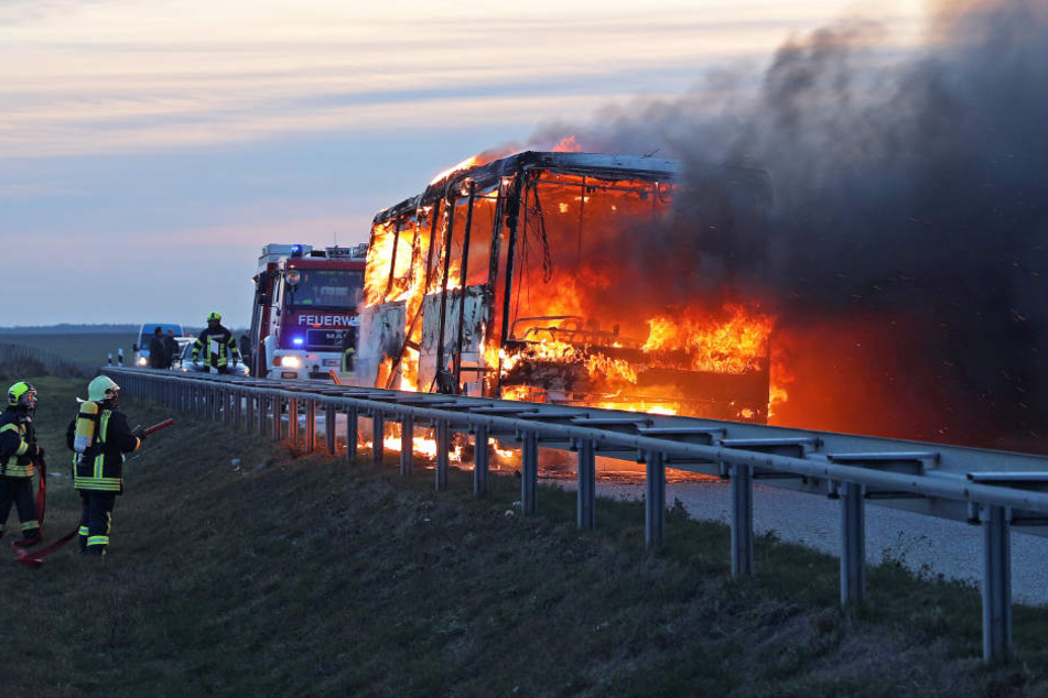 Dunkler Rauch steigt über dem brennenden Bus auf.
