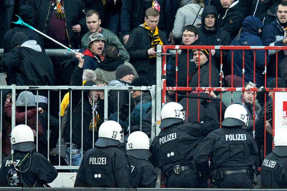 Ein Dynamo-Fan schlägt mit einer Krücke zurück, nachdem die Polizei Pfefferspray in den Dresdner Block gesprüht hatte.