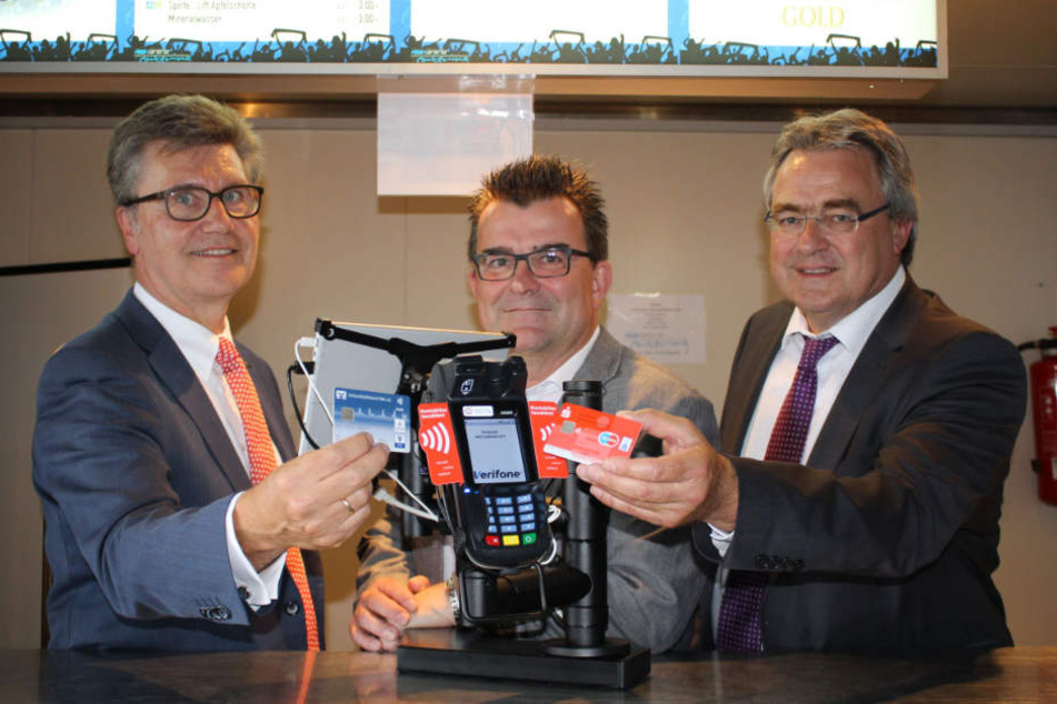Hubert Böddeker (Vorstand Sparkasse Paderborn-Detmold), Martin Hornberger (SCP-Geschäftsführer) und Karl-Heinz Rawert (Vorstand VerbundVolksbank OWL eG) zeigen das kontaktlose Bezahlen.