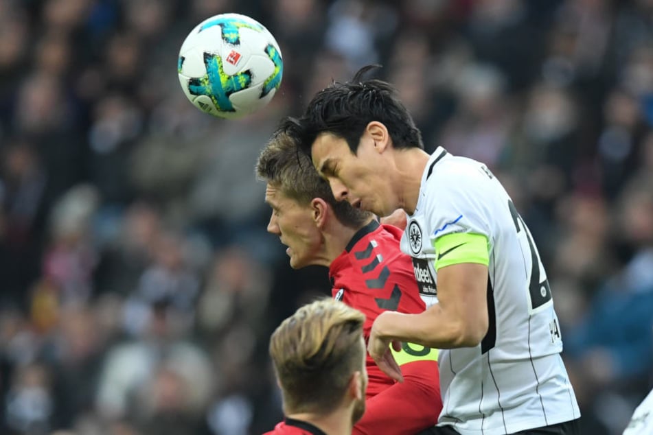 Makoto Hasebe (re.) gewinnt das Kopfball-Duell gegen Nils Petersen.