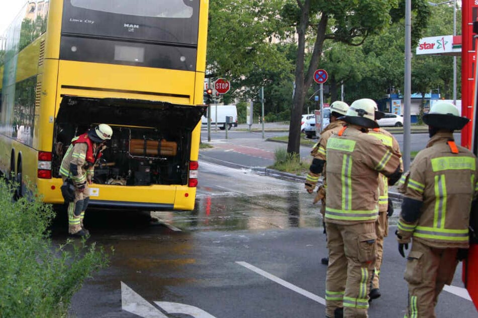 Feuerwehrmänner checken den Heckbereich des Doppeldeckers.