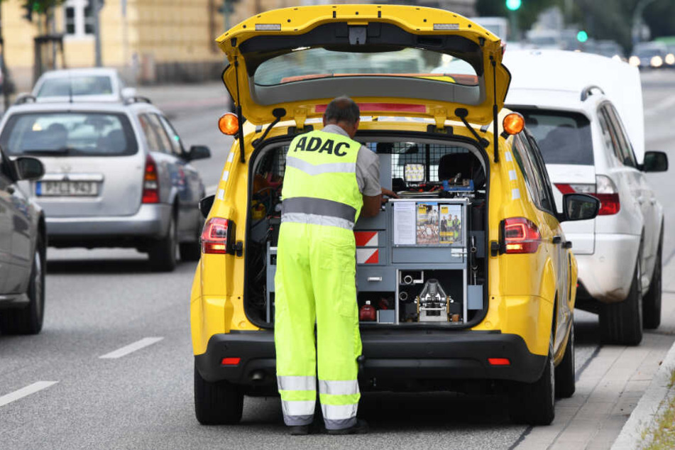 Ein Pannenhelfer steht hinter seinem Fahrzeug.