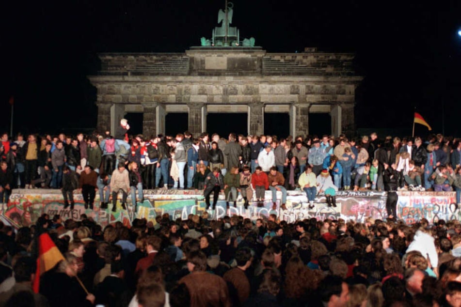 10. November 1989: Jubelnde Menschen auf der Berliner Mauer am Brandenburger Tor.