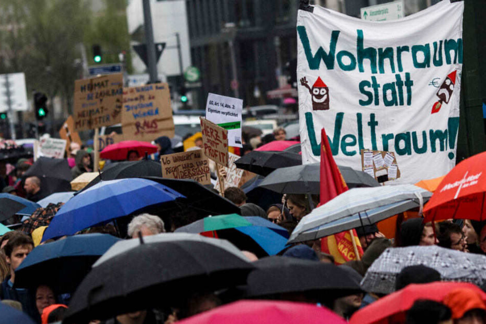 Demonstranten protestieren gegen Wohnungsmangel und Mietsteigerungen und tragen u.a. ein Plakat "Wohnraum statt Weltraum!".