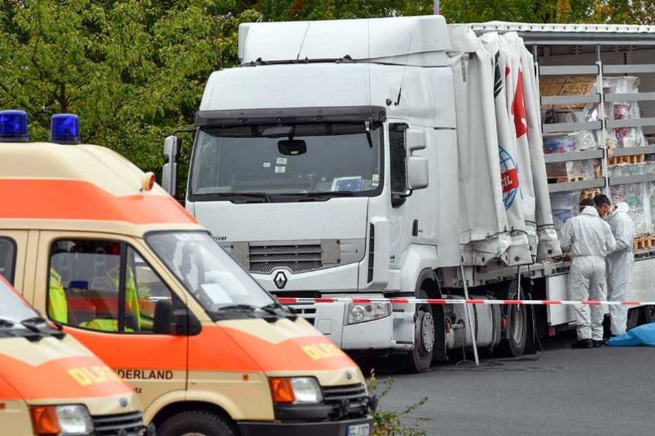Ermittler stehen an dem Laster, in dem 51 Menschen zwischen der Ladung versteckt waren.