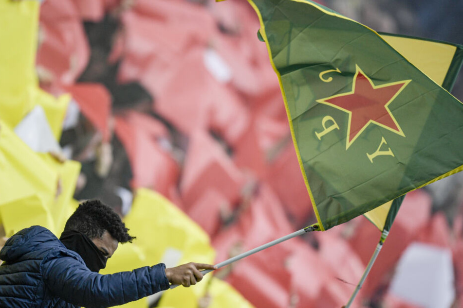 St. Paulis Fans halten Fahnen der kurdischen Frauenverteidigungseinheiten YPJ in die Höhe.