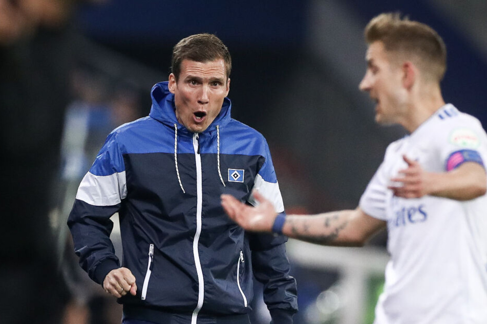 Trainer Hannes Wolf versucht Kapitän Lewis Holtby Anweisungen zu geben.