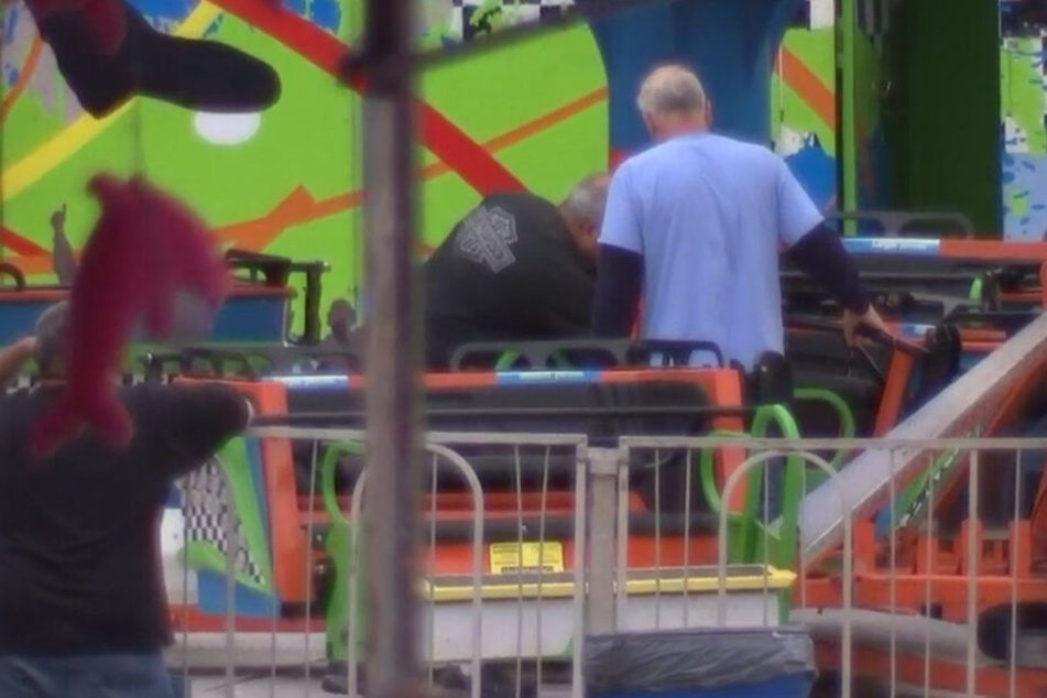 Männer untersuchen das Karussell nach dem Unglück.