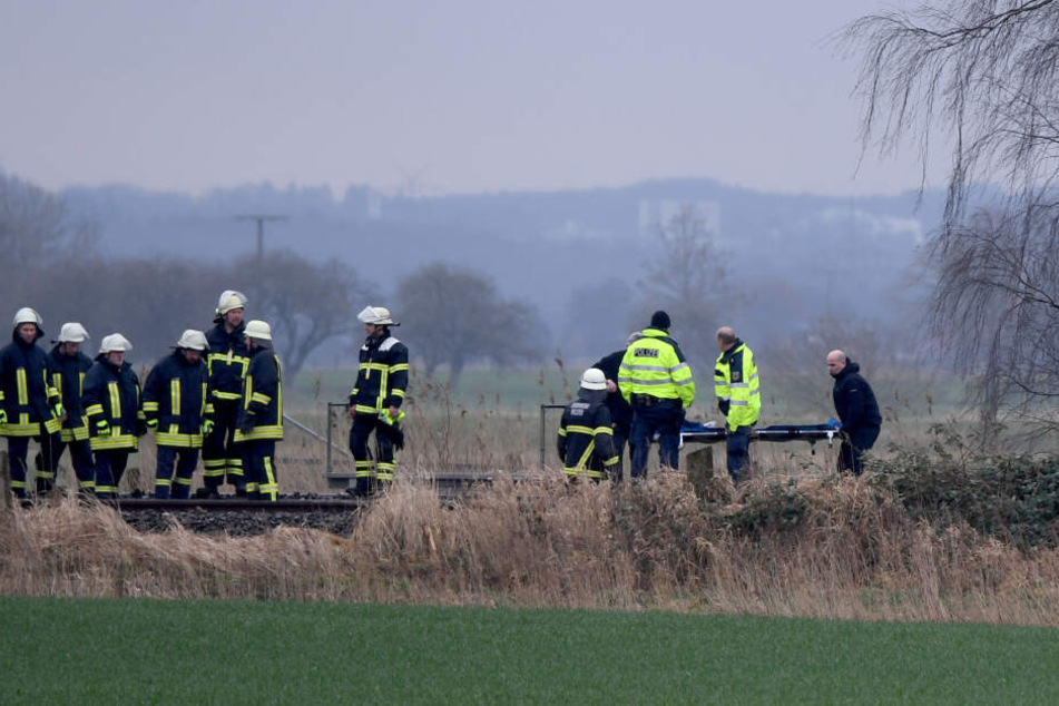 Feuerwehrmänner stehen an der Unglückstelle auf der Bahnstrecke Hamburg-Sylt nahe Wilster.