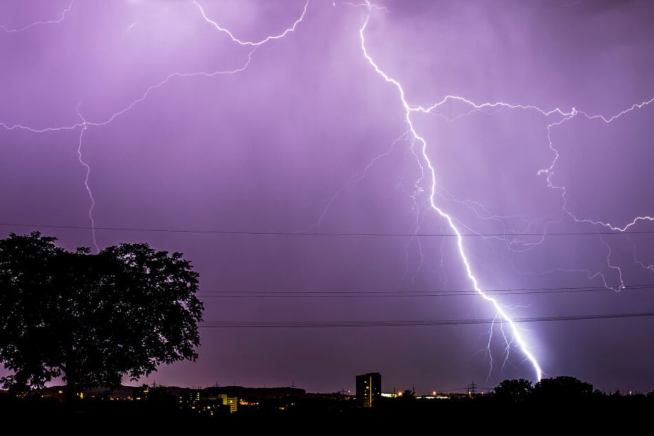 Blitze zucken während eines Gewitters am abendlichen Himmel über Stuttgart, Baden-Württemberg.