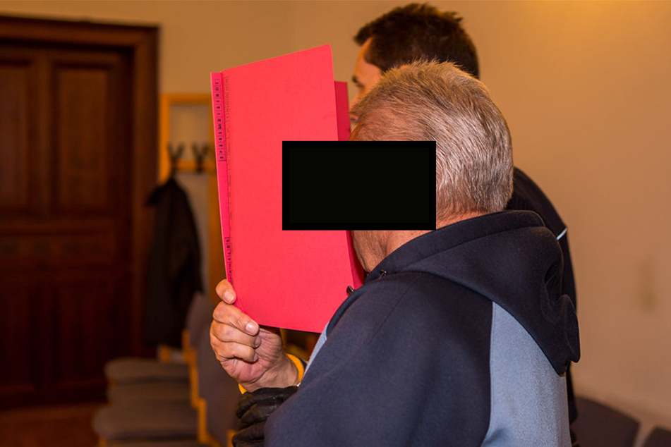 Versteckte sein Gesicht hinter einem roten Hefter: Kinderschänder Norbert H. (69) auf dem Weg zur Anklagebank.