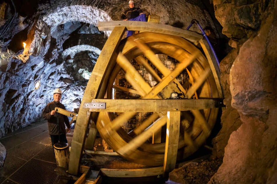 Bergführer Jens Wagner (46, l.) und Holzkünstler Knut Beyer (33) mit dem neuen Wasserrad im Bergwerk des Fortuna Stolln.