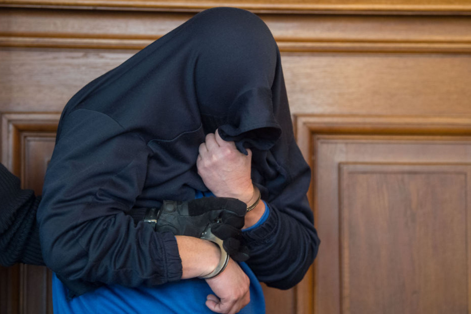Ein Sarg wird in einen Leichenwagen gehoben. Es handelt sich dabei um eines der Opfer des Angeklagten.