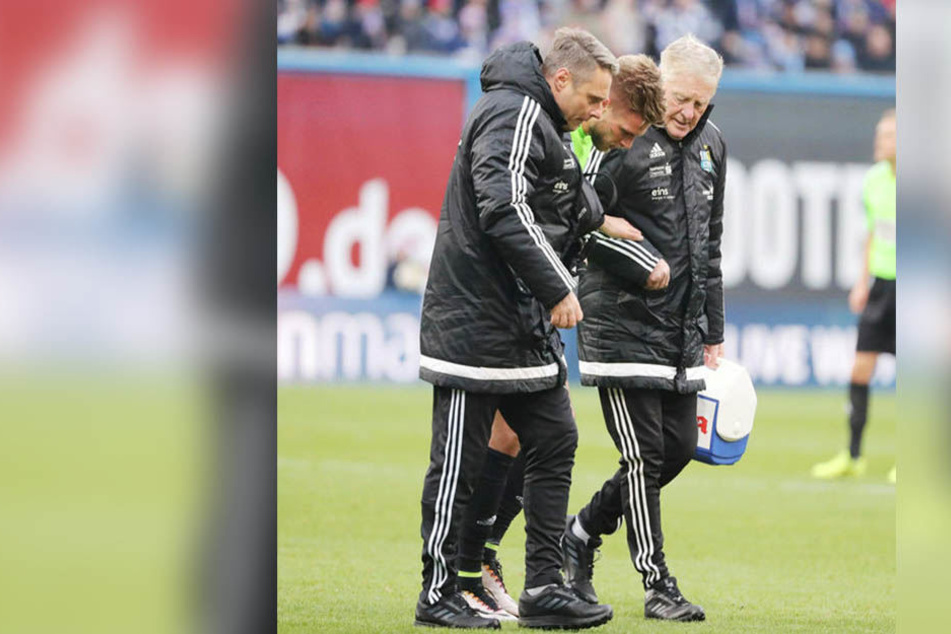 Rostock, 10. Dezember: Der verletzte Florian Trinks (M.) wird von Physio Olaf Renn (l.) und Busfahrer Rainer Kräher vom Platz geführt.