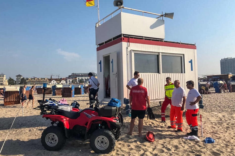 Einsatzkräfte beraten sich am Strand von Warnemünde.