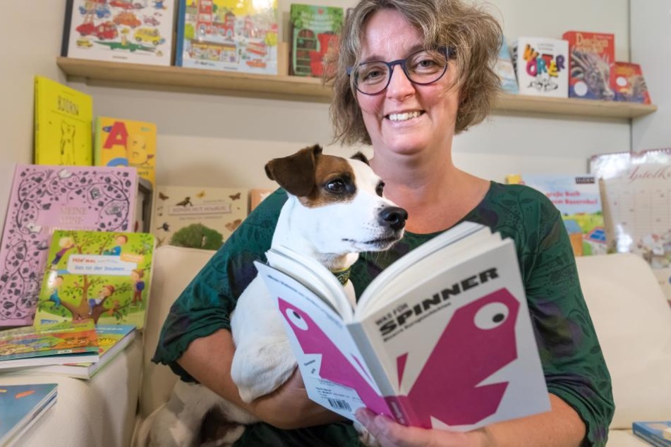 Wenke Helmboldt (49), hier mit Hund Fred (5) und ihrem Lieblingsbuch "Was für Spinner", leitet seit Jahren erfolgreich ihre Buchhandlung "Universitas".