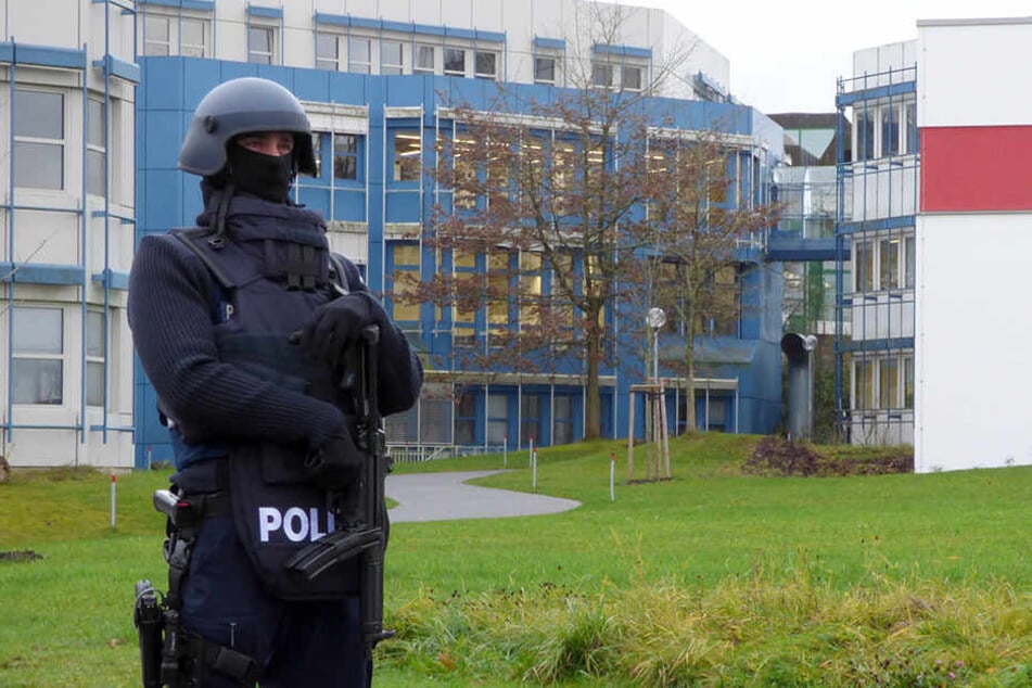 Ein Polizist steht am 24.11.2017 vor einem Gebäude der Universität Trier. Nach einer Amokdrohung ist am Freitag ein Tatverdächtiger festgenommen worden.