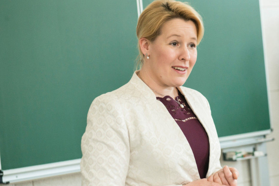 Bundesfamilienministerin Franziska Giffey (SPD) steht vor einer Wandtafel.