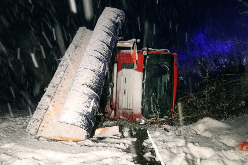 Ein Fahrzeug des Winterdienstes liegt am neben der B312 bei Uttenweiler. Der Fahrer des Schneepfluges war auf der mit Schnee bedeckten Straße von der Fahrbahn abgekommen und auf die Seite gekippt.