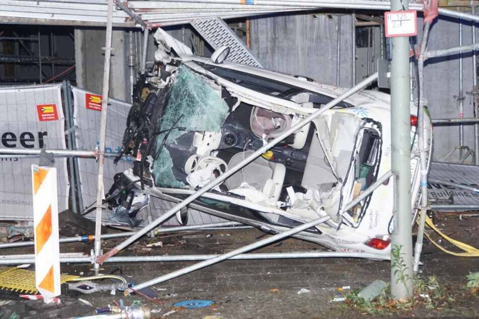 Der Fiat steckt hochkant in dem Baugerüst und ist völlig zerstört.