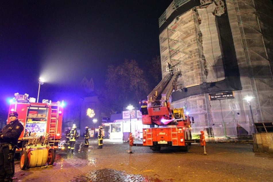 Einsatzkräfte arbeiten in der Silvesternacht an der Reinoldikirche in Dortmund: Eine Silvesterrakete hatte am Dach ein Fangnetz eines Baugerüsts in Brand gesetzt.